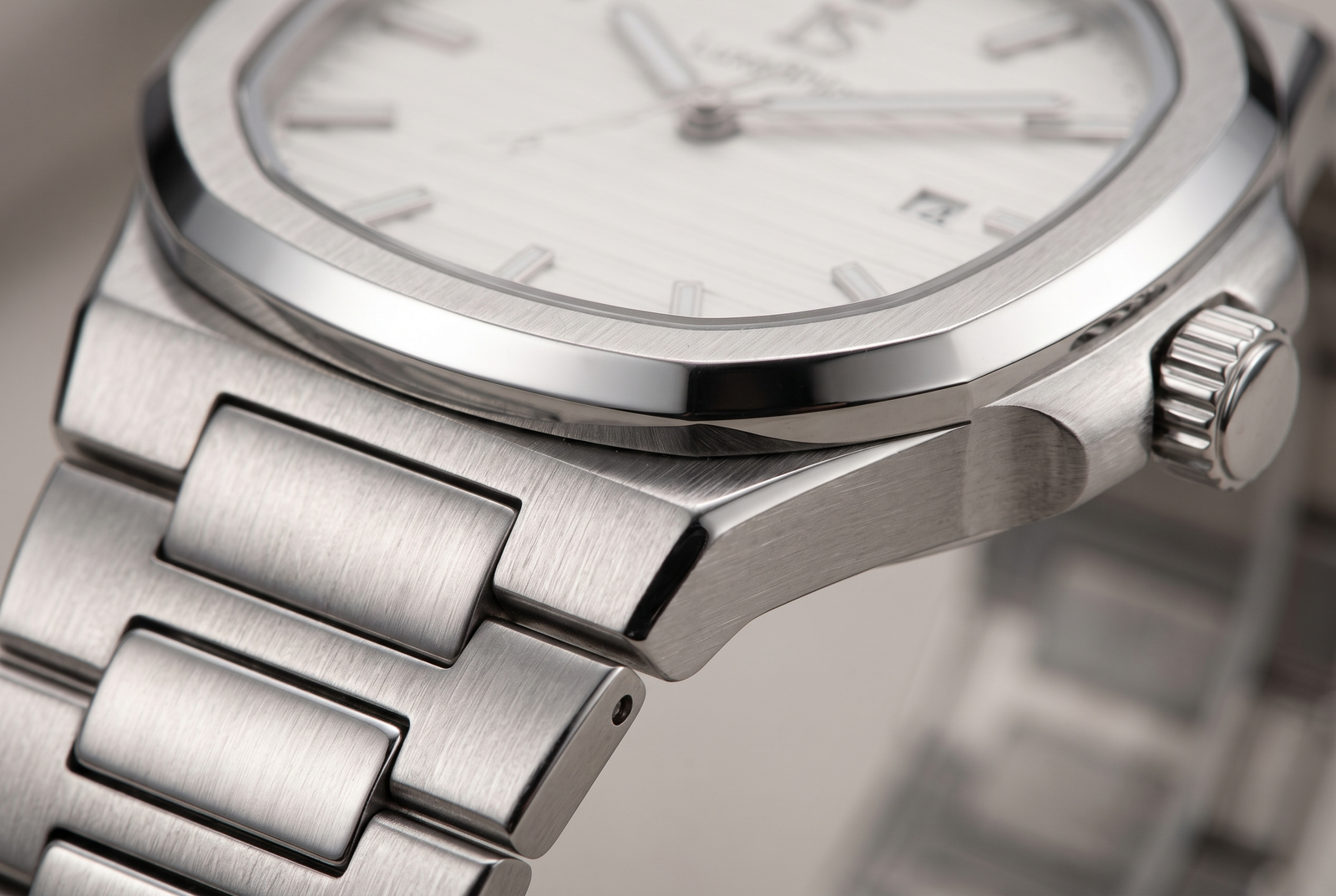 Extreme macro of a LuxeShine CASPIAN watch case and bracelet showing brushed and polished steel finishing.
